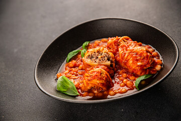 Stuffed cabbage tomato sauce with beans meat, cabbage, fresh delicious gourmet food background on the table rustic food top view copy space