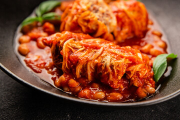 Stuffed cabbage tomato sauce with beans meat, cabbage, fresh delicious gourmet food background on the table rustic food top view copy space