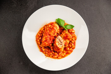 Stuffed cabbage tomato sauce with beans meat, cabbage, fresh delicious gourmet food background on the table rustic food top view copy space