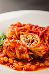 Stuffed cabbage tomato sauce with beans meat, cabbage, fresh delicious gourmet food background on the table rustic food top view copy space