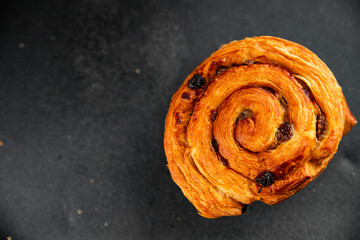 Fototapeta premium Raisin bun sweet pastry dessert puff pastry fresh delicious gourmet food background on the table rustic food top view copy space