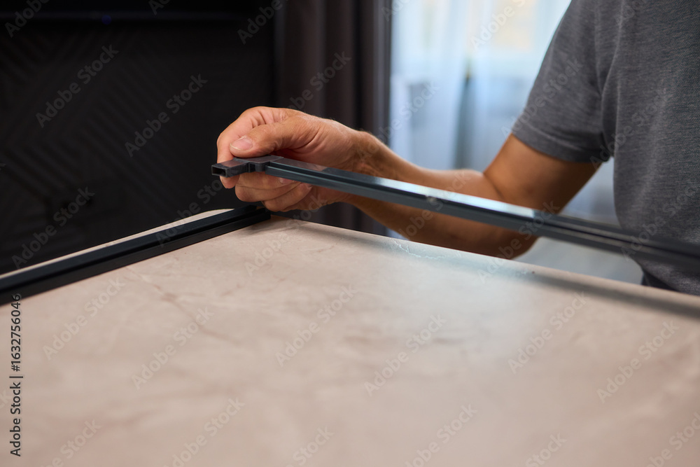 Aufkleber hand assembling a frame on a beautiful and modern table in a creative workspace