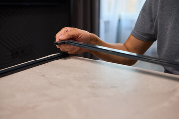 Hand Assembling a Frame on a Beautiful and Modern Table in a Creative Workspace