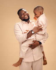 Laughter dances between father and son, frozen mid-embrace in matching beige. This tender portrait...
