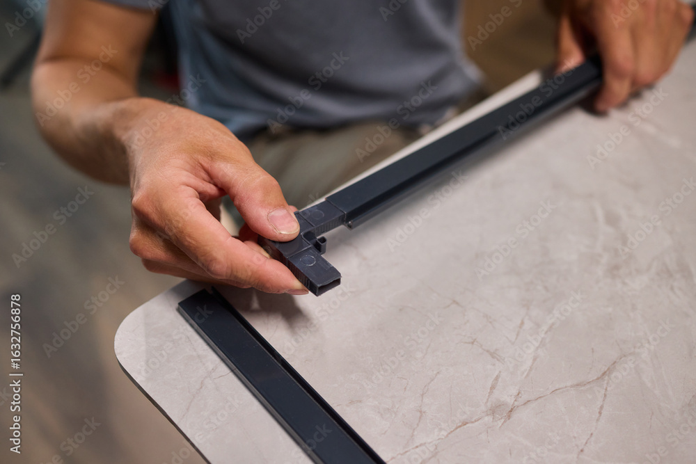 Poster hand assembling a frame on a beautiful and modern table in a creative workspace