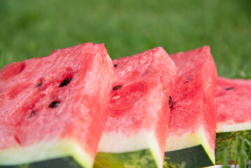 Сlose up of watermelon cut into triangles. Sweet organic fresh juicy red dessert. Summer snack from natural product for a healthy diet