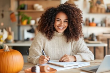 Smiling freelancer writing on notebook working from home in autumn