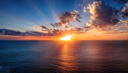 majestic sunset over the ocean with rays illuminating clouds and water in a serene atmosphere
