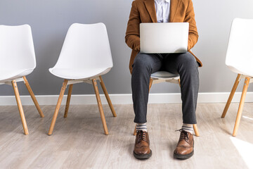 Business Professional Using Laptop While Waiting in a Modern Office Environment
