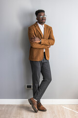 Stylish Man in Formal Outfit Leaning On a Wall in Modern Room