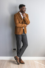 Stylish Gentleman in Smart Casual Attire Posing Against a Neutral Wall