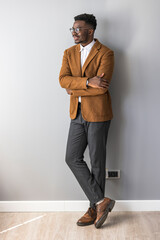 Confident Professional Man Standing in Smart Casual Attire Against Gray Wall
