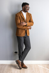 Stylish Businessman Posing Against Gray Wall in Casual and Professional Attire