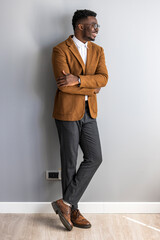 Confident Man Standing Against Wall in Stylish Business Casual Attire