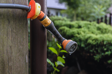 holder of garden hose on a wall of wooden house