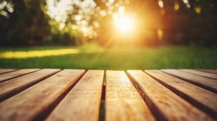 Wooden picnic table top with blurred park background at sunset.