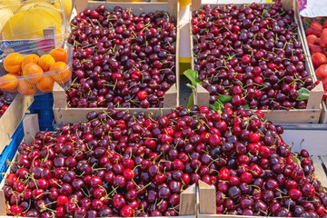 Sweet Cherry Fruits in Wooden Crates at Farmers Market Stall