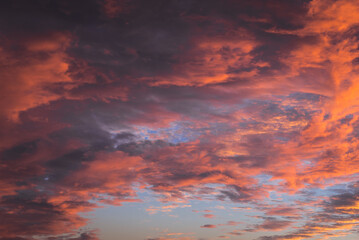 Orange, pink and red clouds during sunset over Warsaw city, Poland