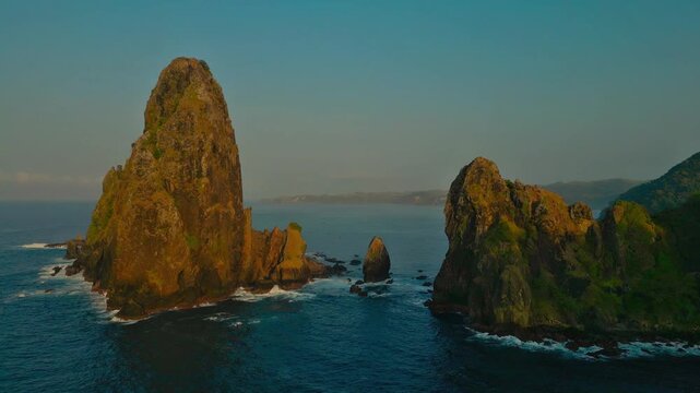 Aerial view of jagged coastal rock formations rising sharply from the ocean along Keben Beach