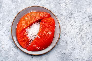 Fresh whole raw red caviar extracted from live trout or salmon with sea salt, grey background, top...
