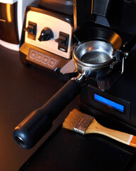 Close-up of an empty portafilter positioned under a professional espresso grinder, ready to receive freshly ground coffee