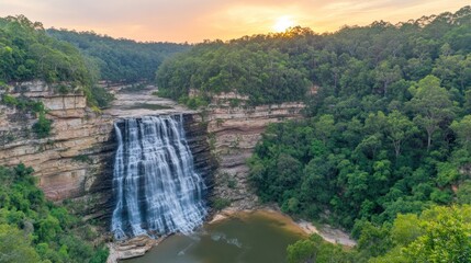 Majestic waterfall cascading down rocky cliffs at sunset.