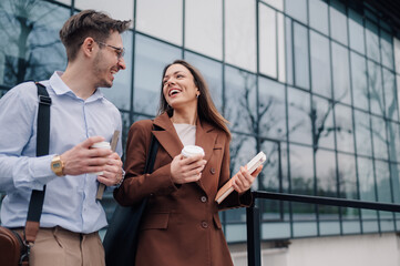 Business people walking and talking outdoors during coffee break