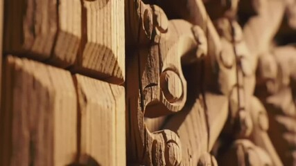 Close-up view of intricately carved, light brown wood panels, exhibiting layered textures and wood grain - Powered by Adobe