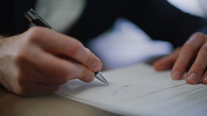 Businessman hand signing legal agreement at office closeup. Unknown entrepreneur
