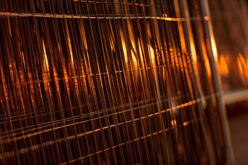 A fine-wire fence at sunset. Galvanized steel reflects the sun's rays. Stainless steel for outdoor...