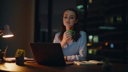 Freelancer relaxing night workplace drinking coffee closeup. Relaxed woman break
