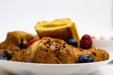 Flaky Croissant with Fresh Berries and Banana on Vibrant Yellow
