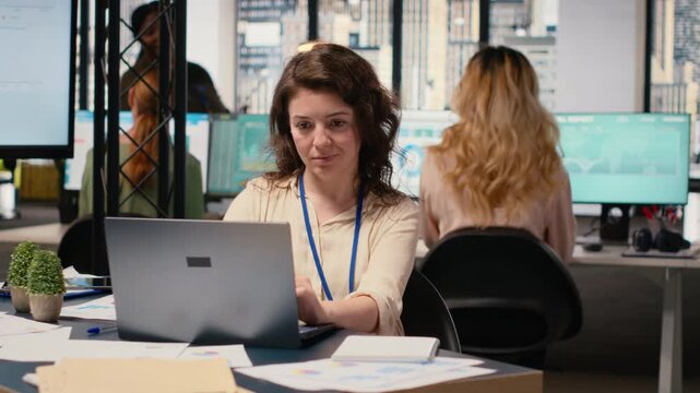 Focused administrator immersed in data analysis and strategic planning, sitting alone at her workstation. Her vision and goals oriented mindset provide success to multinational company. Camera B.