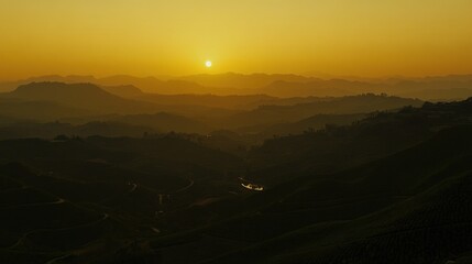 Golden sunrise over a valley of tiered hills.