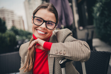 Smiling young professional woman wearing elegant formalwear relaxing outdoors in an urban setting...
