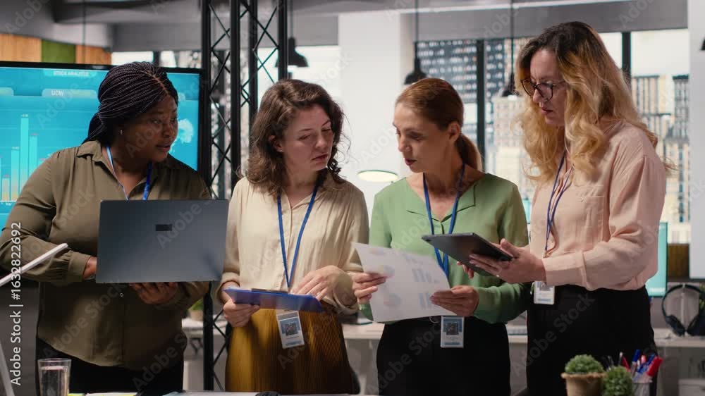 Poster multiethnic women form a powerful team discuss business strategy, analyzing performance data on lapt
