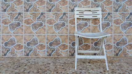 Silla blanca de madera en patio al aire libre.