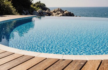 Fototapeta premium Relaxing swimming pool with clear blue water overlooking the ocean and rocky coastline