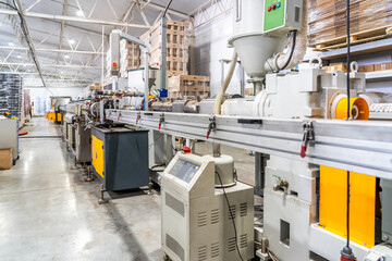 Plastic extrusion manufacturing line in modern industrial factory. Automation, polymer processing,...