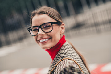 Confident young businesswoman smiling in an urban street, wearing stylish formal attire on a...