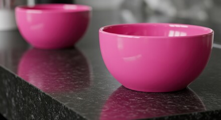 Two pink bowls on a dark countertop