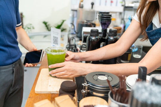 Small business entrepreneur coffee shop barista cafe restaurant. Customer buy beverage using credit card on smartphone app scan QR code at cashier counter making online banking payment at coffee shop.