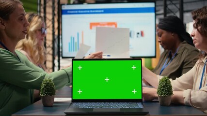 Green screen display on laptop during briefing meeting with female partners, diverse office becomes a powerful visual tool for these businesswomen to present indicators and data reports. Camera A. - Powered by Adobe