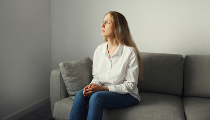 Pensive woman thinks looks out the window, thoughtful girl suffering from depression at home