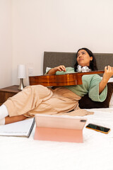 Singer songwriter composing new song on acoustic guitar in bedroom