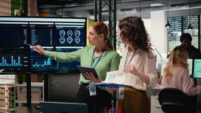 Women employees using performance data analysis to build a strategy in a progressive multinational company, team empowerment for accelerate project goals through efficient planning. Camera A.