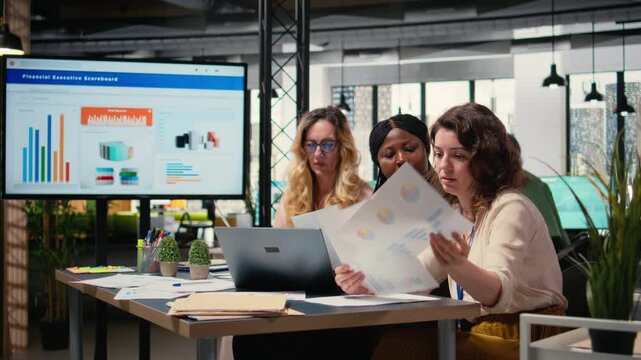 Multiethnic businesswomen exchange insights and challenge ideas in a moment of synergy, aligning performance goals driven by strategic thinking and shared corporate ambition. Camera A.
