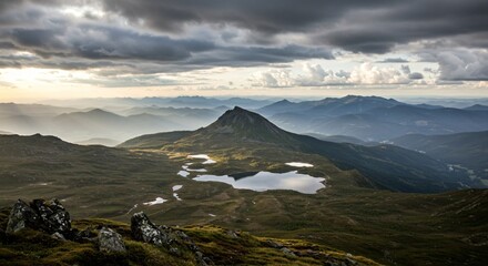 a view from the top of a mountain with a lake and mountains in the background