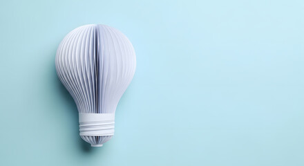 Flat lay of a paper light bulb shape on baby blue background. Creative ideas, focus, innovation.