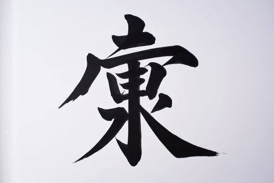 A large Japanese kanji character for longevity is written in black ink on a white background